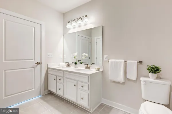a bathroom with a granite countertop sink a toilet and shower