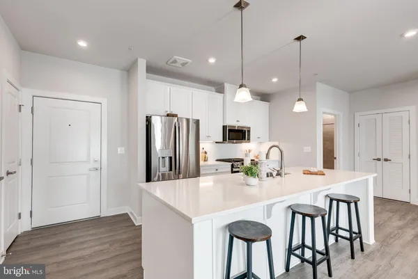 a kitchen with a sink stove and wooden floor