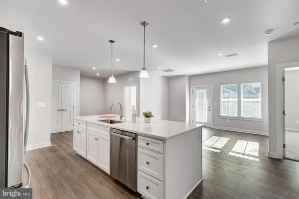 a kitchen with kitchen island granite countertop a sink a center island stainless steel appliances and cabinets