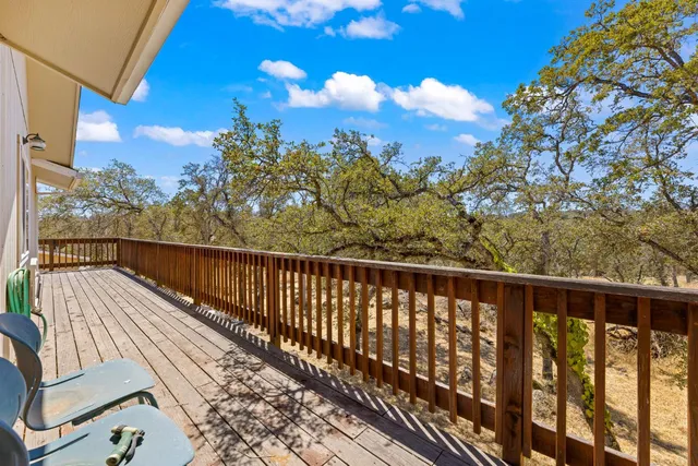 a view of a swimming pool with a patio and wooden fence