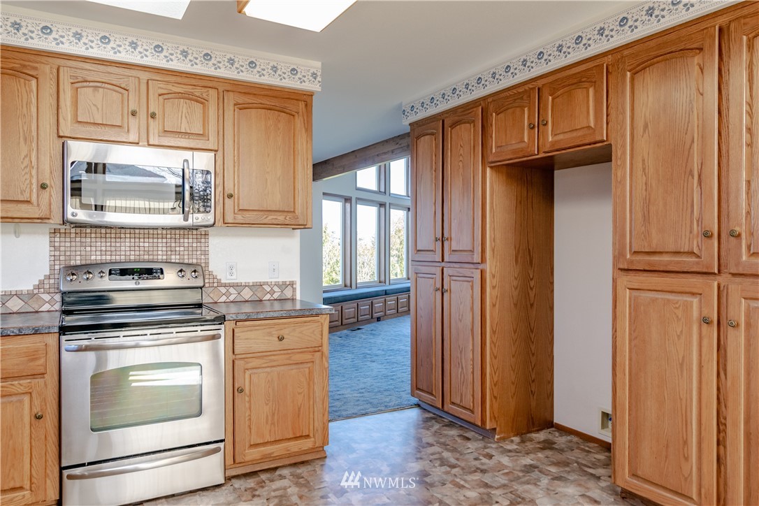 449 Guy Kelly Road Port Angeles, WA 98362 - Photo 16 of 40 a kitchen with granite countertop wooden cabinets and stainless steel appliances