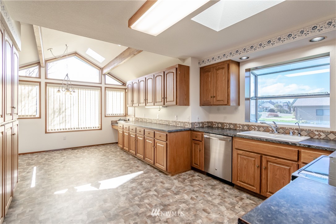 449 Guy Kelly Road Port Angeles, WA 98362 - Photo 17 of 40 a large kitchen with stainless steel appliances granite countertop a sink and a stove next to a window