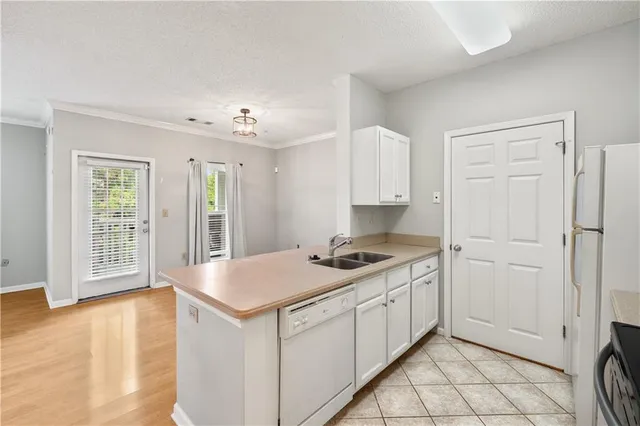 a kitchen with white cabinets and wooden floor