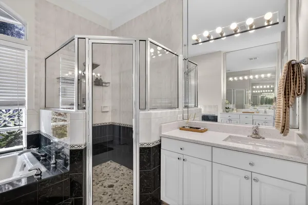 a en suite bathroom with double vanity and a bathtub