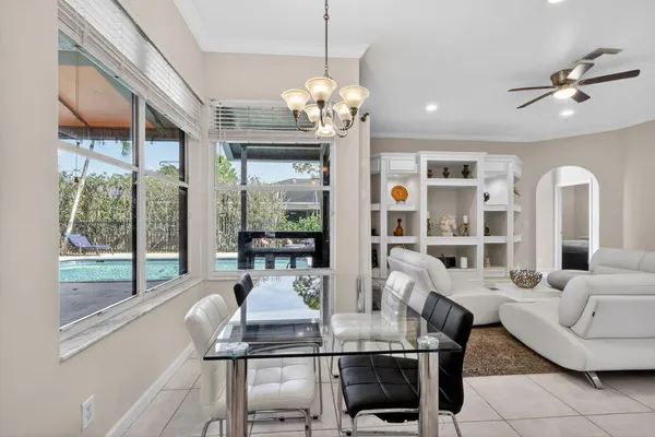 a dining room with furniture a chandelier and window