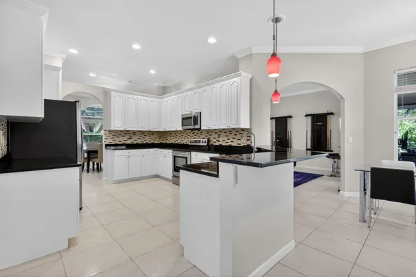 a kitchen with stainless steel appliances granite countertop a sink and a refrigerator