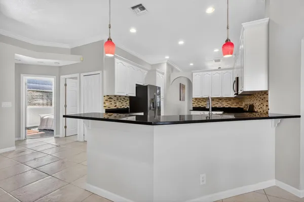 a kitchen with granite countertop white cabinets and stainless steel appliances