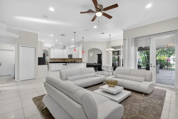 a living room with furniture kitchen view and a chandelier