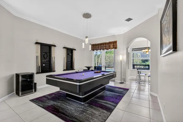 a living room with furniture pool table and chandelier