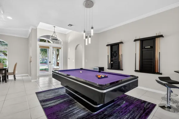 a living room with furniture pool table and chandelier