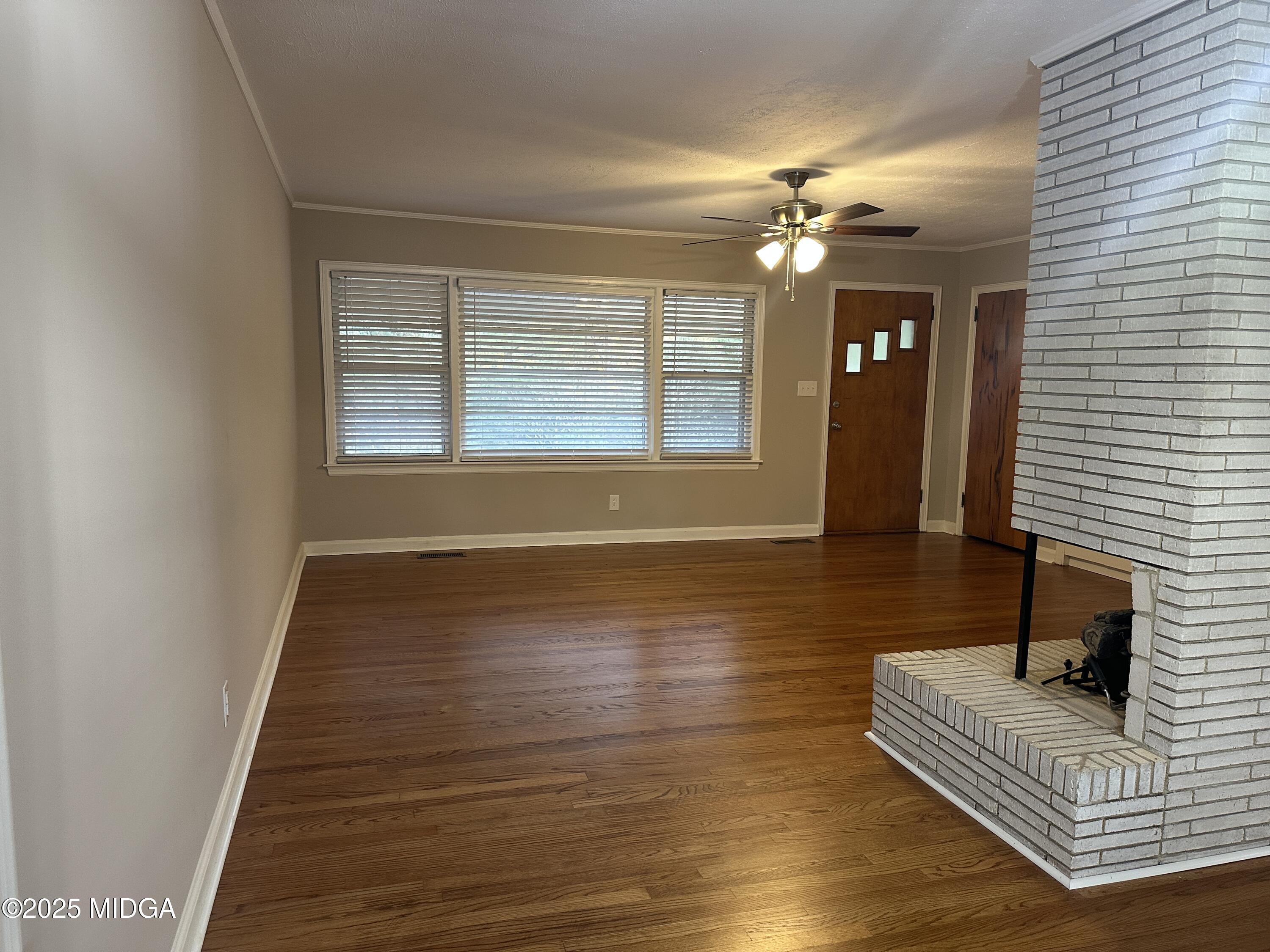 2526 Old Holton Road Macon, GA 31204 - Photo 3 of 19 a view of a livingroom with wooden floor and a ceiling fan