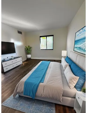 a spacious bedroom with a bed and a flat screen tv