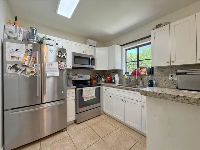 a kitchen with stainless steel appliances granite countertop a refrigerator sink and microwave