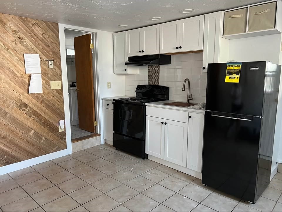 76 Lowell Street, Unit B Peabody, MA 01960 - Photo 4 of 5 a kitchen with a refrigerator stove and cabinets