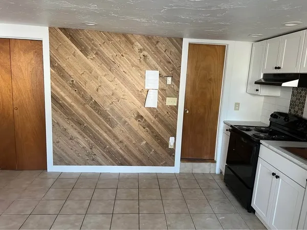 a view of a kitchen in an empty room and wooden floor
