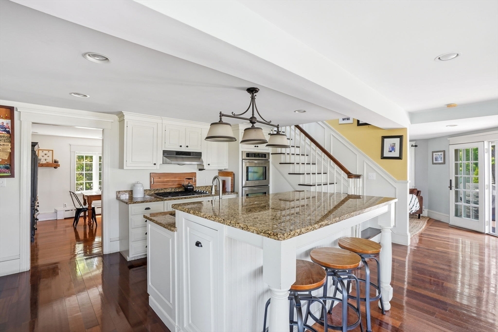 3 Talbot Road Hingham, MA 02043 - Photo 7 of 34 a kitchen with stainless steel appliances granite countertop a stove oven a dining table and chairs with wooden floor