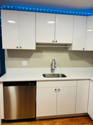 a kitchen with a sink cabinets and wooden floor