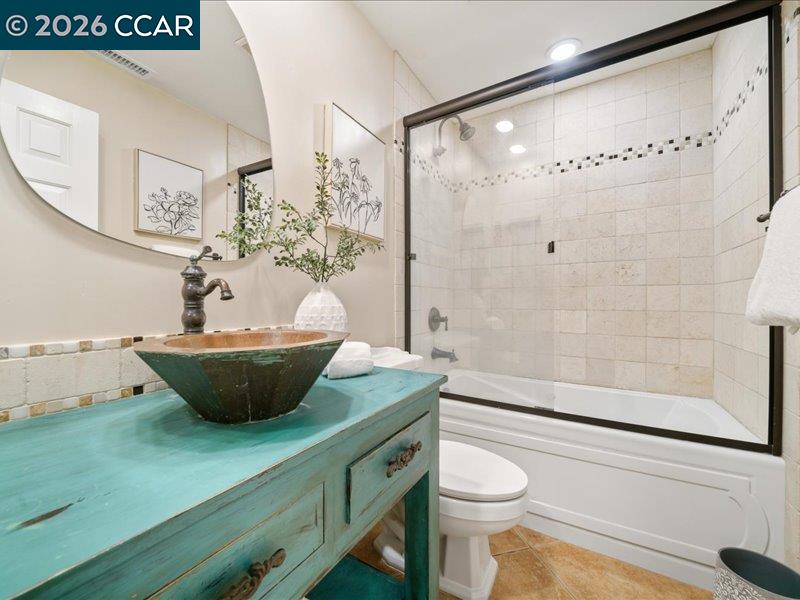 400 Fernando Court San Ramon, CA 94583 - Photo 17 of 38 a view of a bathroom with a granite countertop sink a toilet a mirror and shower