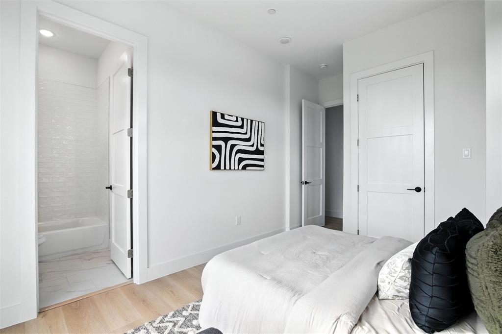 4611 Fairmount Street, Unit 102 Dallas, TX 75219 - Photo 13 of 25 a bedroom with a bed and a painting on the wall
