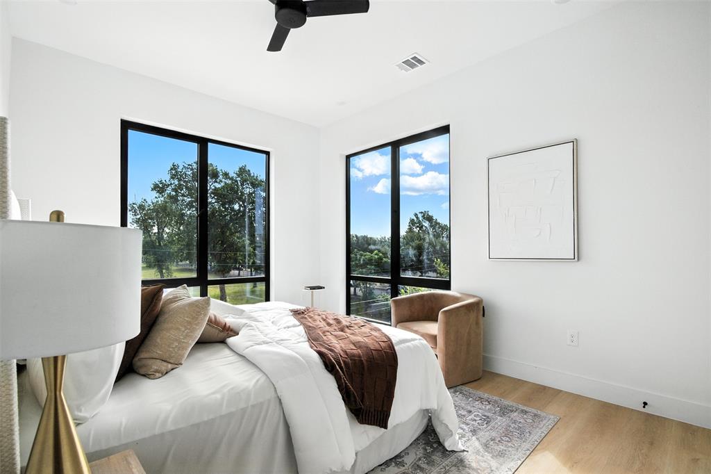 4611 Fairmount Street, Unit 102 Dallas, TX 75219 - Photo 6 of 25 a bedroom with a bed and wooden floor