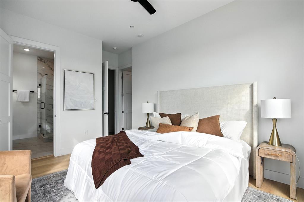 4611 Fairmount Street, Unit 102 Dallas, TX 75219 - Photo 7 of 25 a bedroom with a bed and a lamp