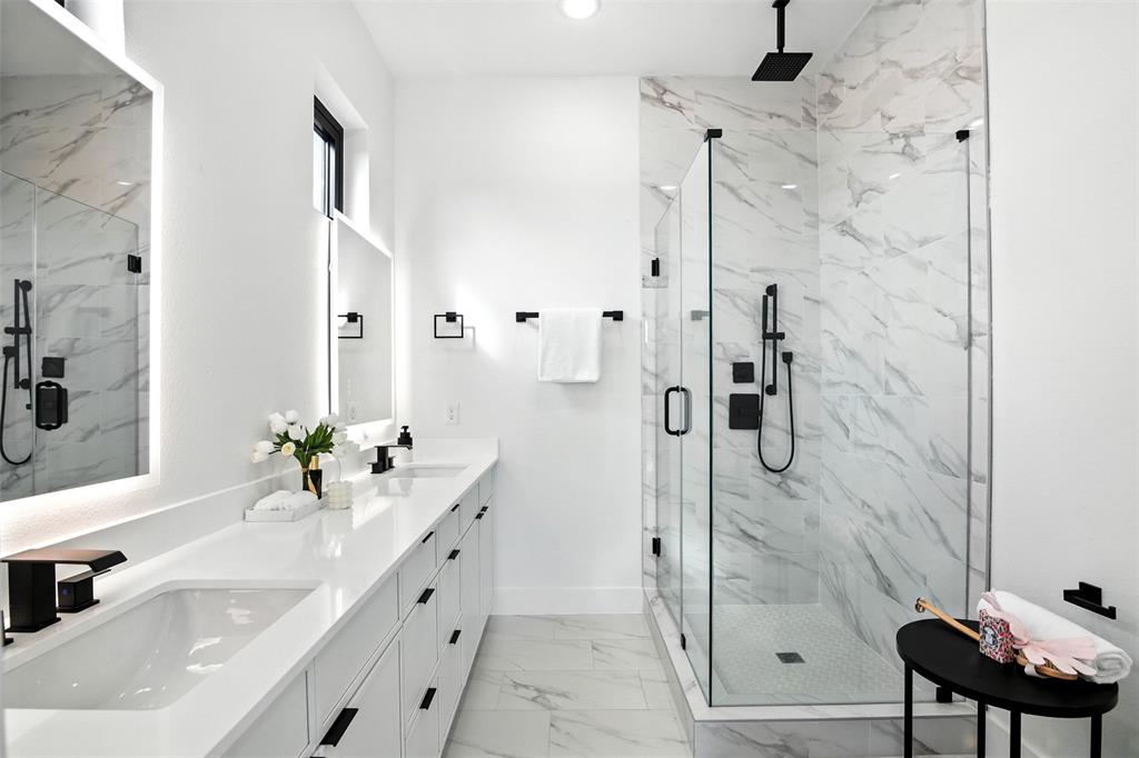 4611 Fairmount Street, Unit 102 Dallas, TX 75219 - Photo 8 of 25 a bathroom with a double vanity sink mirror and shower