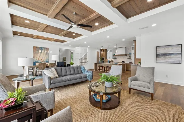 a living room with furniture and a view of kitchen