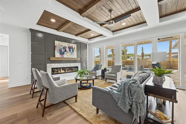 a living room with furniture floor to ceiling window and wooden floor