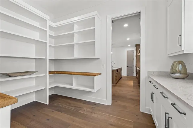 a view of a kitchen with wooden floor and cabinets