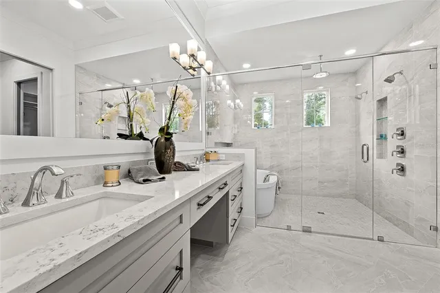 a bathroom with a granite countertop sink a toilet and shower