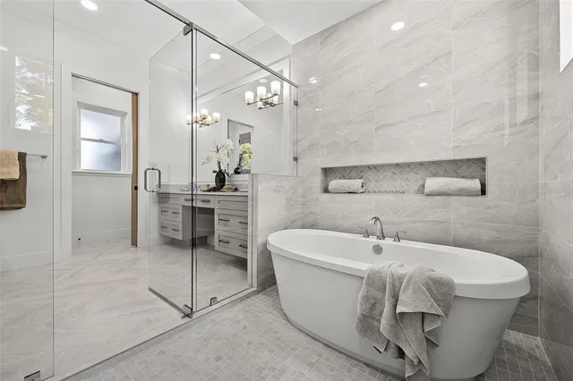 a white bath tub sitting in a bathroom and a sink