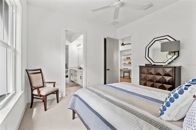 a bedroom with a bed a mirror and a potted plant