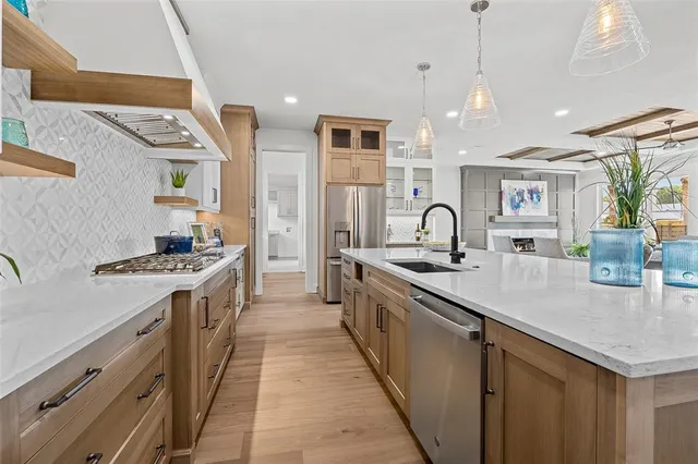 a kitchen with cabinets a sink and stainless steel appliances