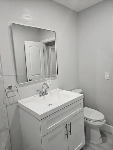 a bathroom with a sink toilet and mirror