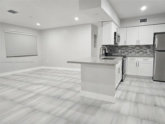 a kitchen with stainless steel appliances granite countertop a sink stove and cabinets