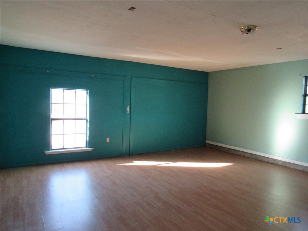 1325 Paseo Del Cobre Temple, TX 76502 - Photo 12 of 15 an empty room with wooden floor and windows with curtains