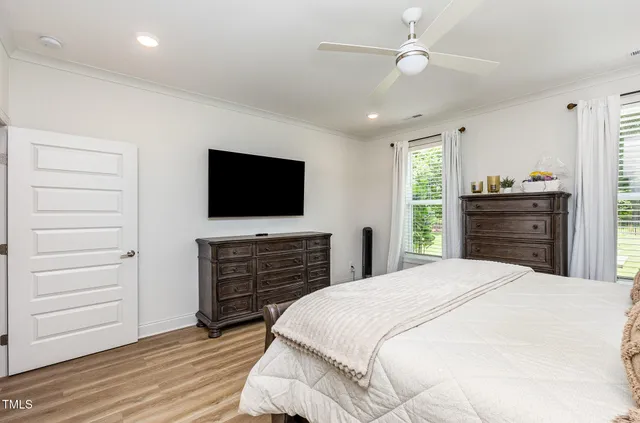 a bedroom with a bed and wooden floor