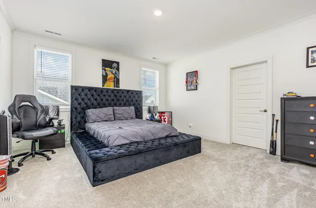 a spacious bedroom with a bed and chair