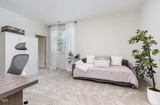 a bedroom with a bed and a potted plant