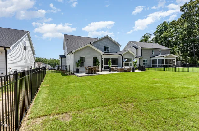 a view of a house with a big yard plants and large trees