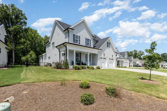 a front view of a house with a yard and trees