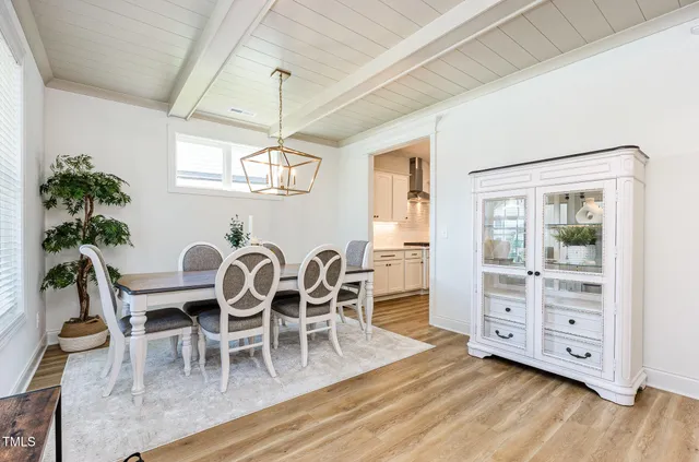a dining room with furniture a chandelier and wooden floor