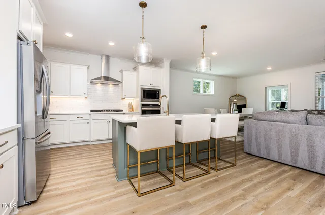 a large kitchen with a table chairs refrigerator and cabinets