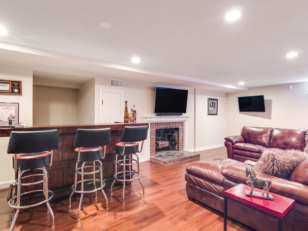 128 Locksley Road Lynnfield, MA 01940 - Photo 25 of 38 a living room with furniture a dining table and a fireplace