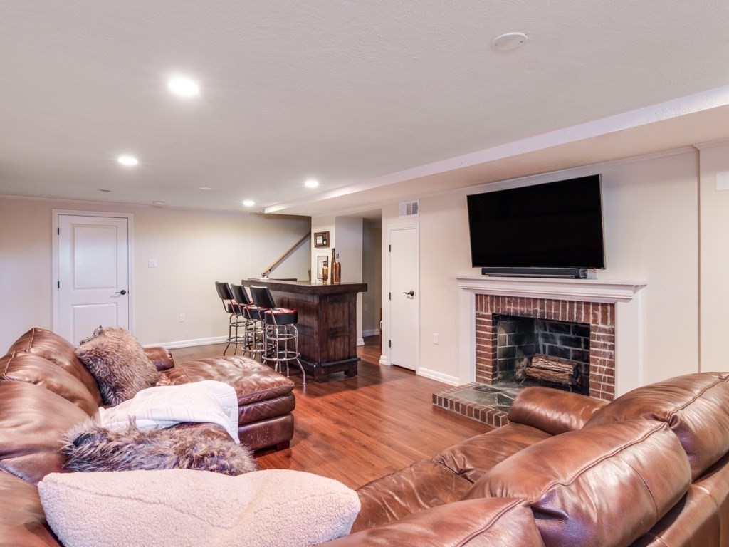128 Locksley Road Lynnfield, MA 01940 - Photo 26 of 38 a living room with furniture a fireplace and a flat screen tv