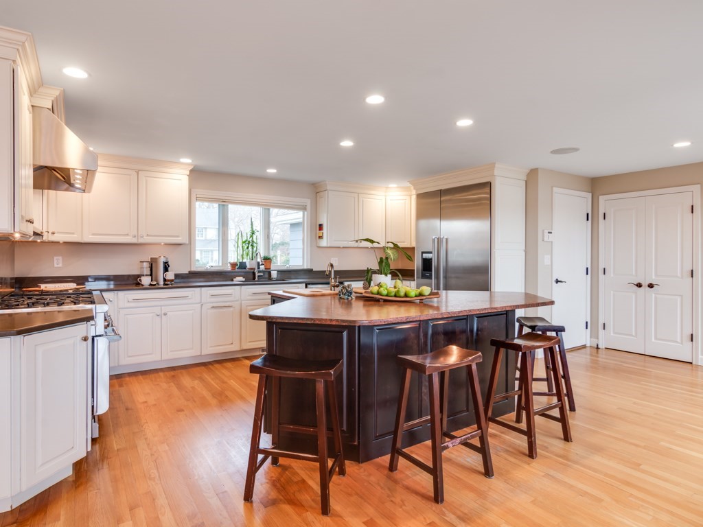 128 Locksley Road Lynnfield, MA 01940 - Photo 8 of 38 a kitchen with stainless steel appliances kitchen island granite countertop a table chairs sink and cabinets
