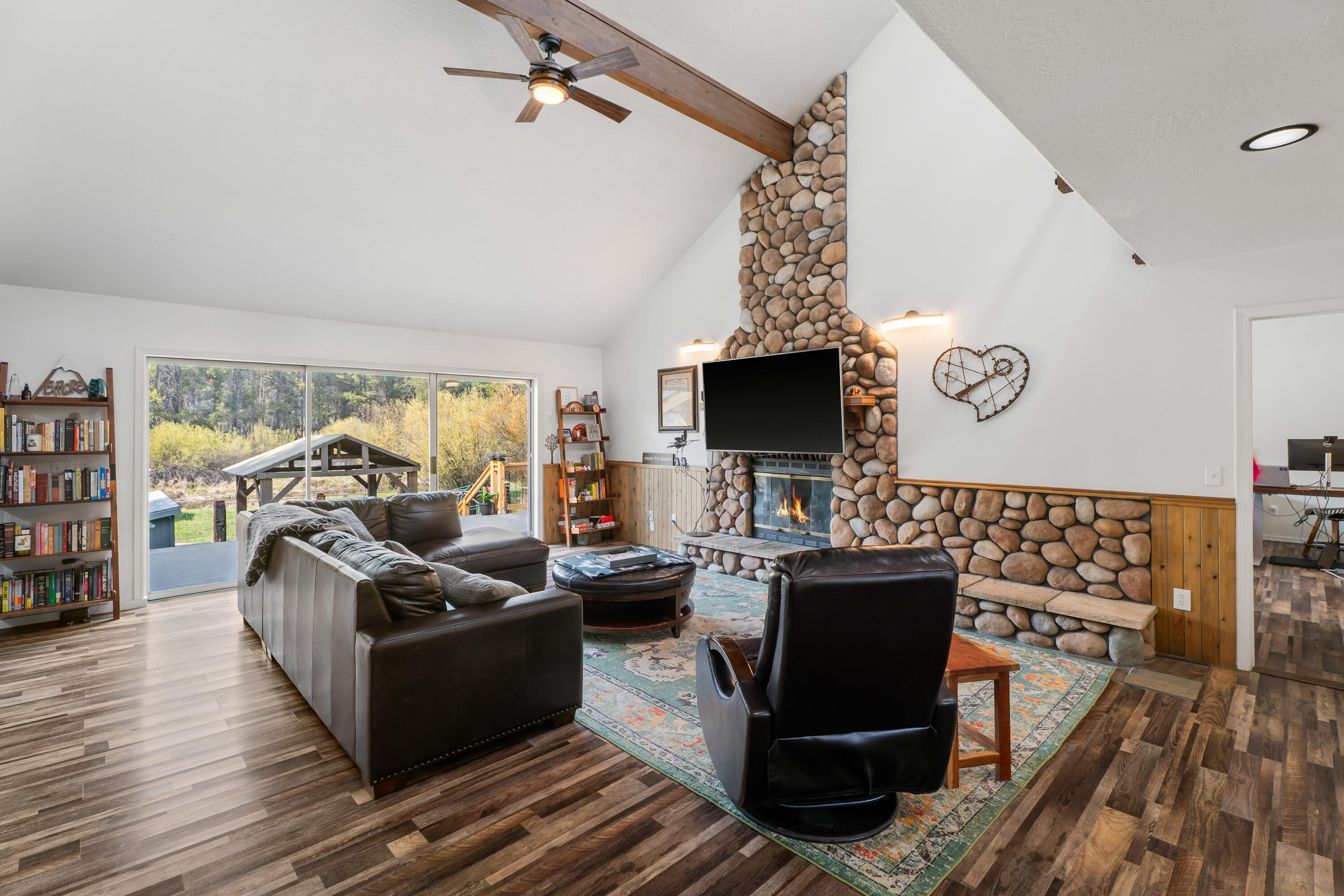 17062 Milky Way Bend, OR 97707 - Photo 9 of 39 Living room reveal from the loft with vaulted ceilings and floor-to-ceiling river-rock fireplace