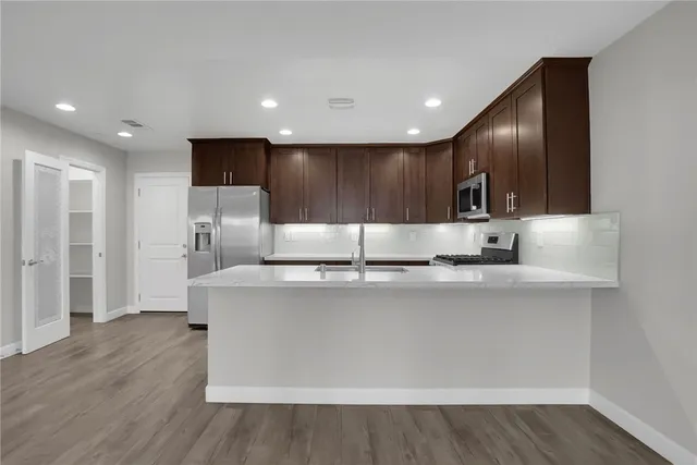 a kitchen with stainless steel appliances a refrigerator sink and stove