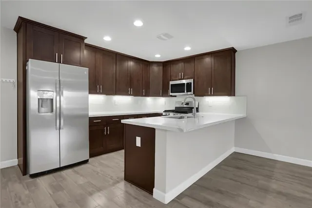 a kitchen with granite countertop stainless steel appliances a sink stove top oven and cabinets
