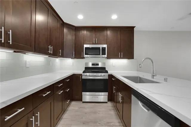 a kitchen with a sink a refrigerator and cabinets